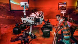 father and son looking at robot in Journey to Mars Explorers Wanted exhibit at Kennedy Space Center Visitor Center in Orlando, Florida, USA